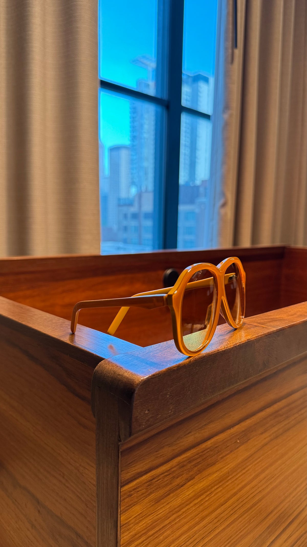 Handcrafted orange acetate luxury eyewear by ANNTURE with tinted lenses, bold sculptural frame from the “…in the morning” collection